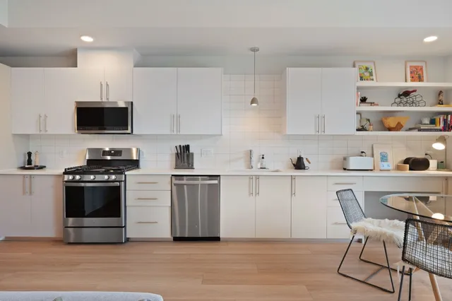 a kitchen with stainless steel appliances a stove a sink and a refrigerator