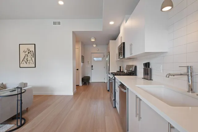 a kitchen with a sink cabinets and wooden floor