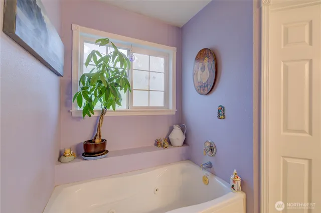 a bathroom with a tub and a potted plant