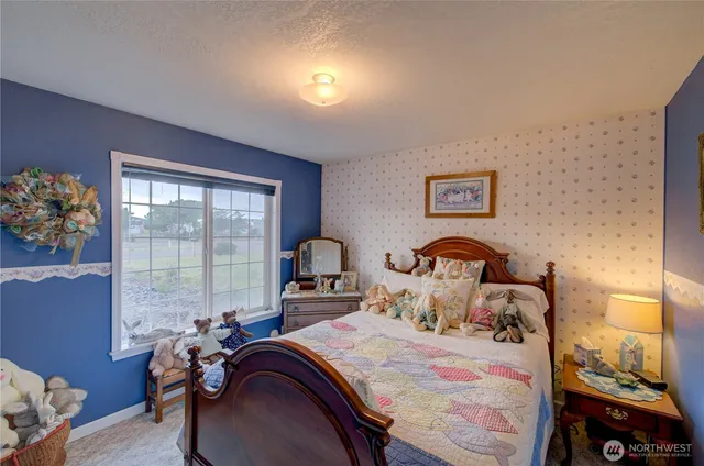 a bedroom with a bed and a large window with the outer view