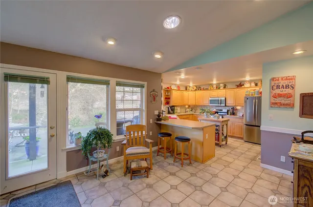 a large white kitchen with a large window and furniture