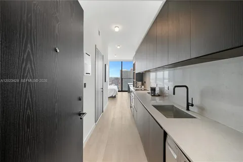 a kitchen with a sink a counter top space stainless steel appliances and cabinets