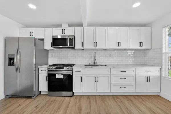 a kitchen with stainless steel appliances granite countertop a stove a sink and a refrigerator