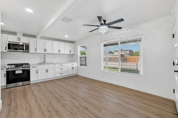 a kitchen with stainless steel appliances granite countertop a stove a sink and a microwave