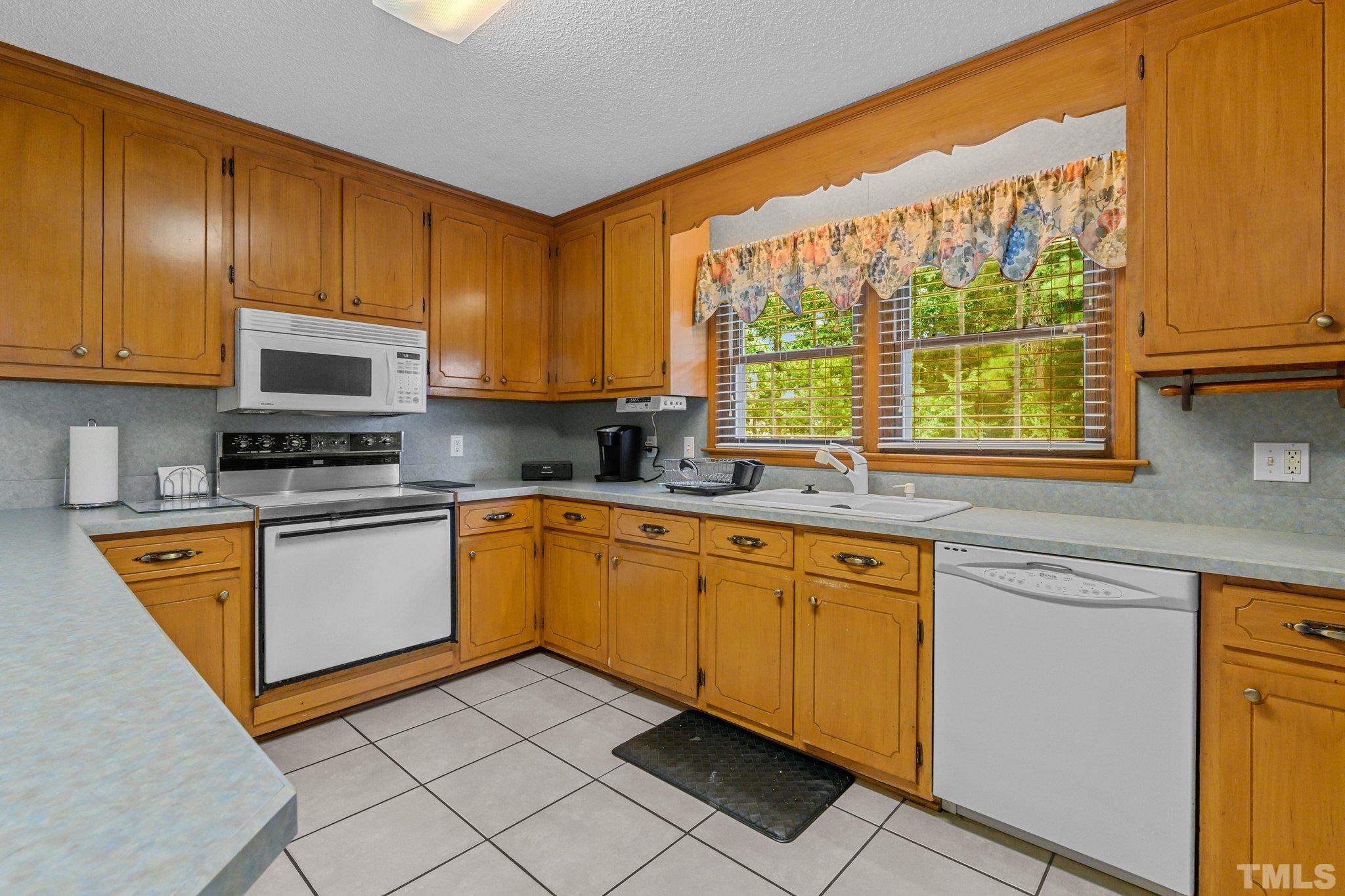 705 Sherron Road Durham, NC 27703 - Photo 17 of 28 a kitchen with stainless steel appliances granite countertop a stove a sink and a microwave