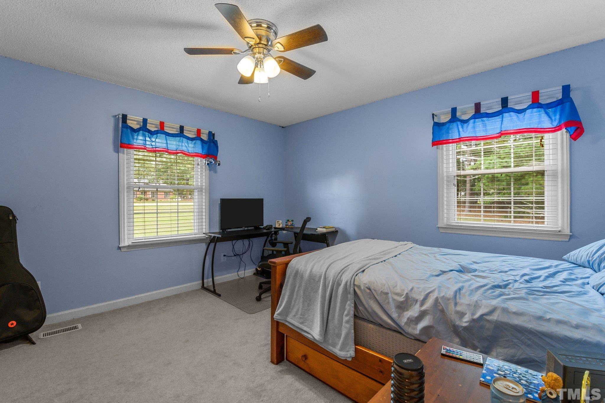 705 Sherron Road Durham, NC 27703 - Photo 20 of 28 a bedroom with a bed and a chandelier