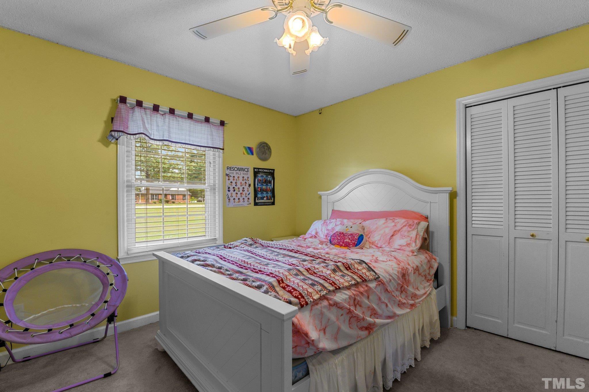705 Sherron Road Durham, NC 27703 - Photo 22 of 28 a bedroom with a bed and a chandelier