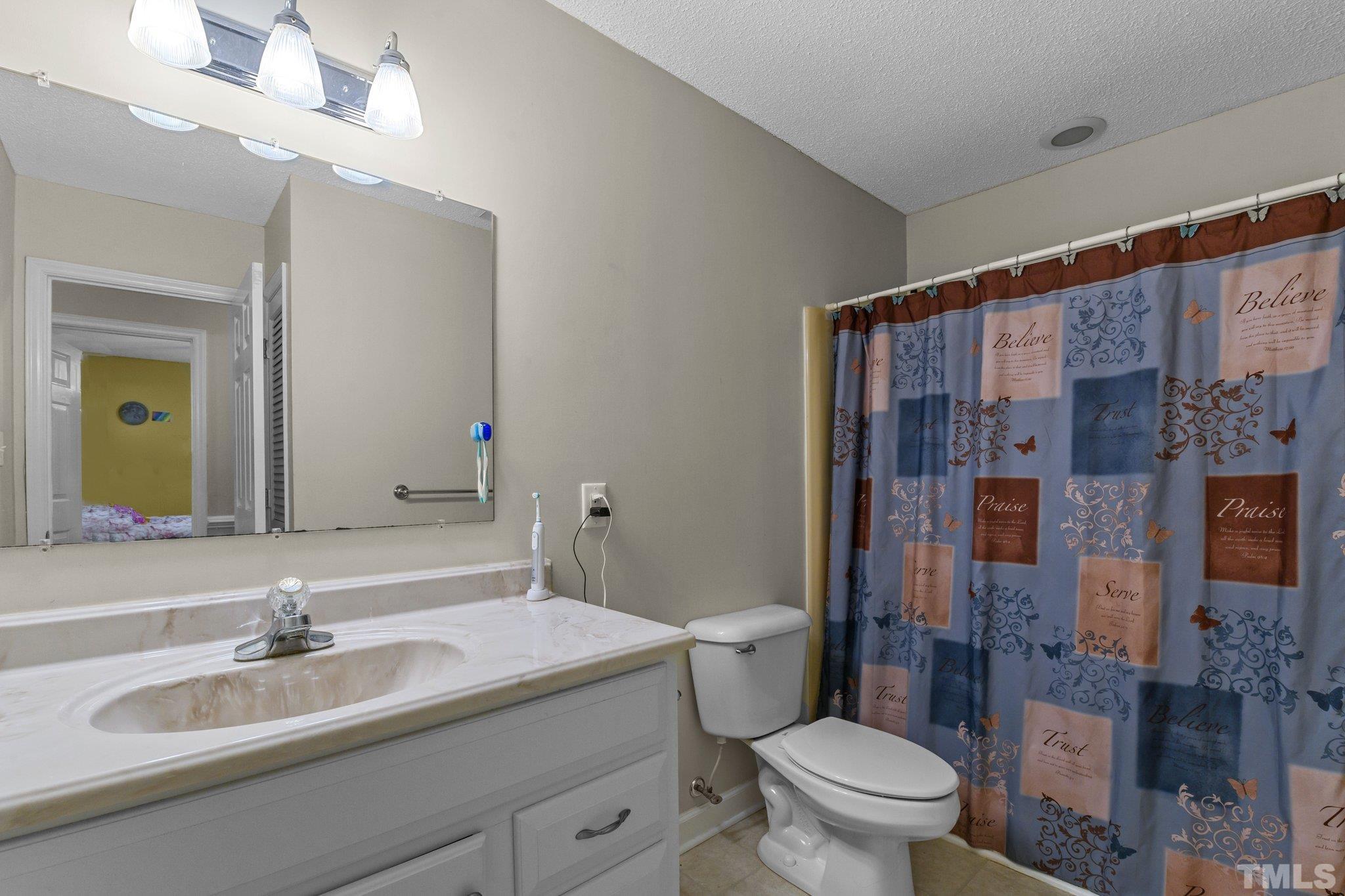 705 Sherron Road Durham, NC 27703 - Photo 28 of 28 a bathroom with a sink a toilet a mirror and shower