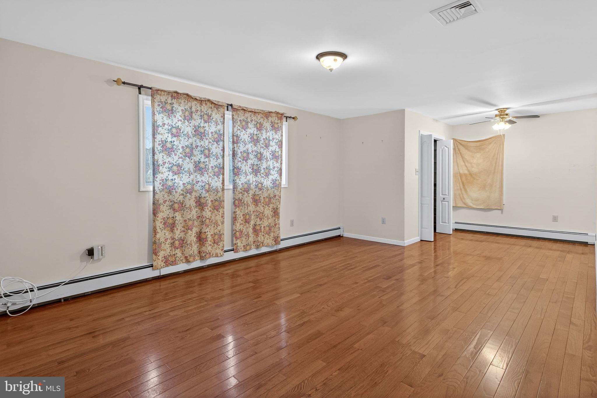 764 Lakehurst Road Browns Mills, NJ 08015 - Photo 25 of 36 a view of an empty room with wooden floor and a window