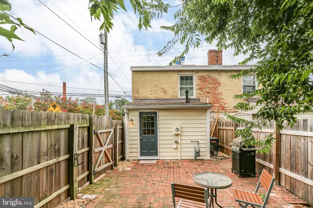 a view of a chair and table in backyard of the house