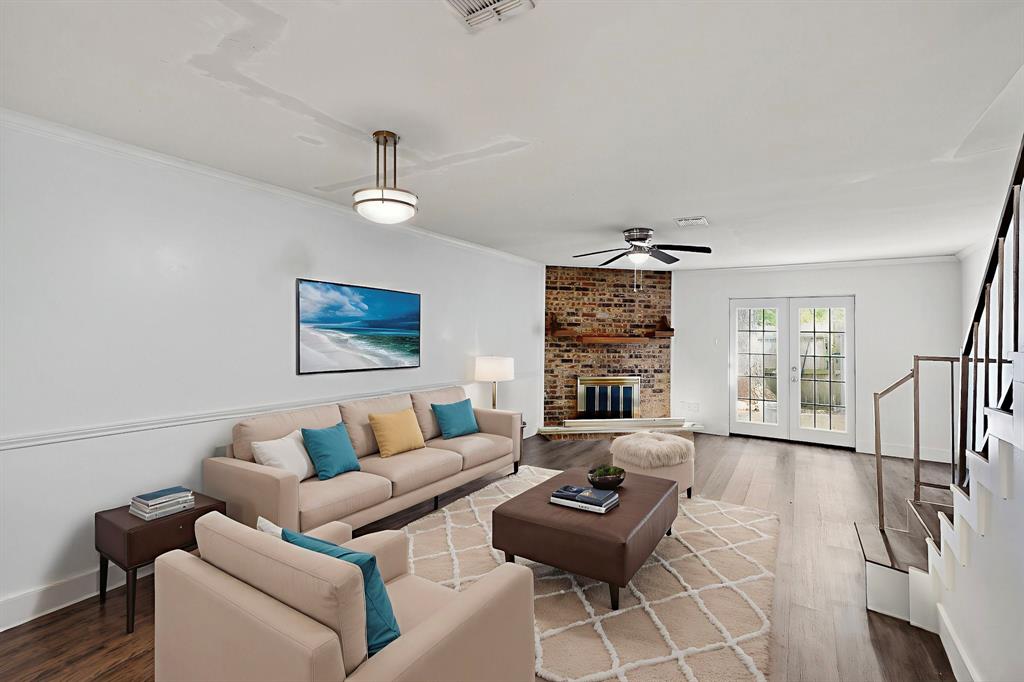 46 Abbey Road Euless, TX 76039 - Photo 15 of 16 Living room featuring crown molding, dark wood-type flooring, a brick fireplace, french doors, and ceiling fan