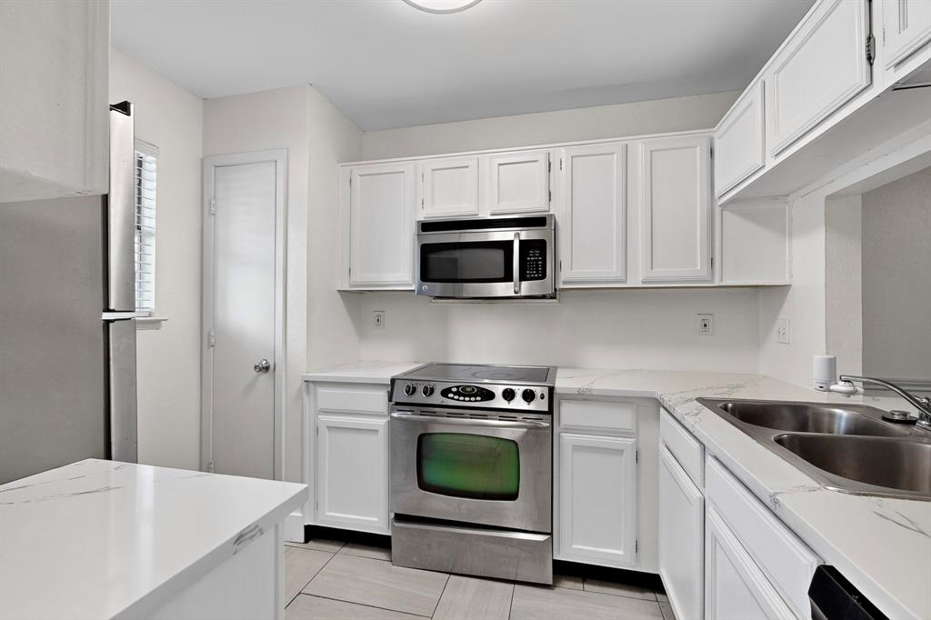 46 Abbey Road Euless, TX 76039 - Photo 4 of 16 Kitchen featuring stainless steel appliances, white cabinets, and light stone countertops