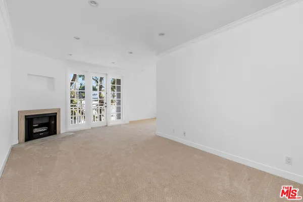 a view of an empty room with a fireplace and a window