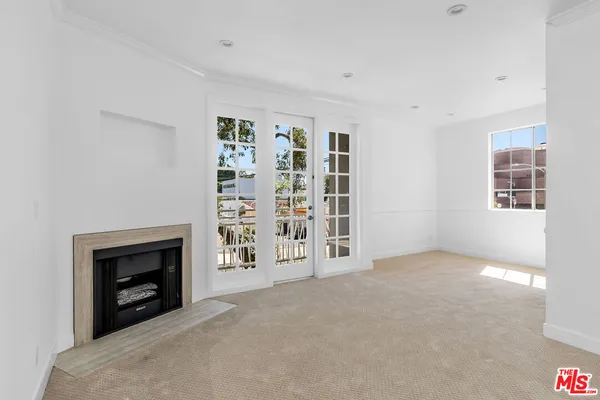 a view of an empty room with a fireplace and a window