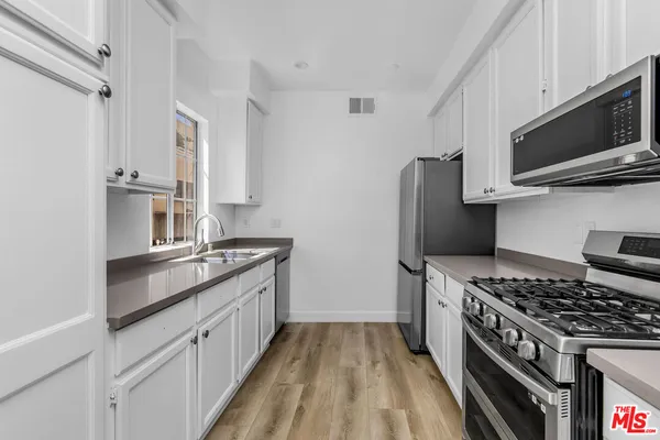 a kitchen with stainless steel appliances granite countertop a stove and a refrigerator