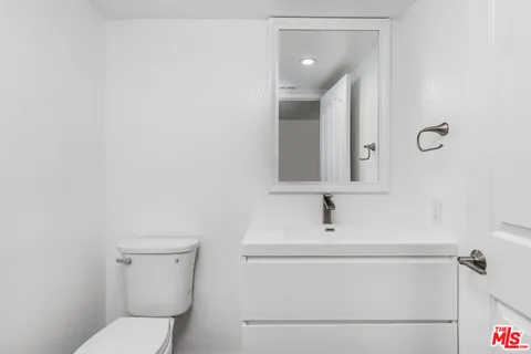 a bathroom with a toilet sink and mirror