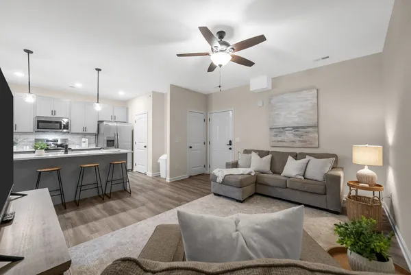 a living room with furniture and kitchen view