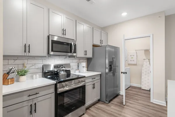 a kitchen with stainless steel appliances a stove microwave and refrigerator