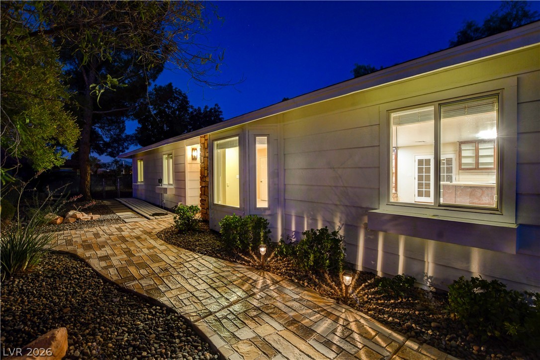 7631 Bermuda Road Las Vegas, NV 89123 - Photo 57 of 64 An inviting stone pathway with subtle landscaping lighting leads to a home at twilight.