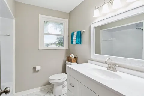 a bathroom with a toilet sink and mirror