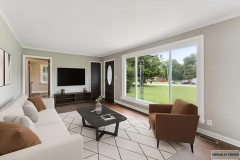 a living room with furniture a flat screen tv and a large window