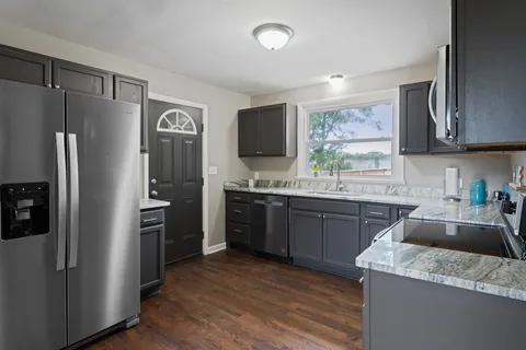a kitchen with granite countertop stainless steel appliances and wooden cabinets