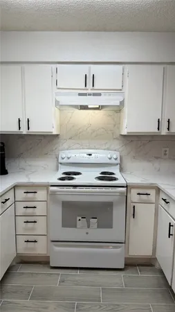 a stove top oven sitting inside of a kitchen