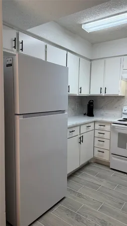 a kitchen with white cabinets and white appliances