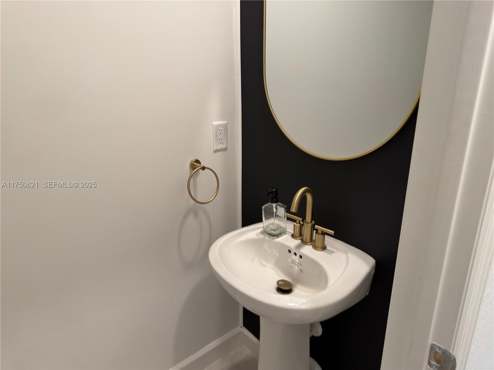 12909 Northwest 23rd Place, Unit 12909 Miami, FL 33167 - Photo 19 of 34 a bathroom with a sink a mirror and a toilet