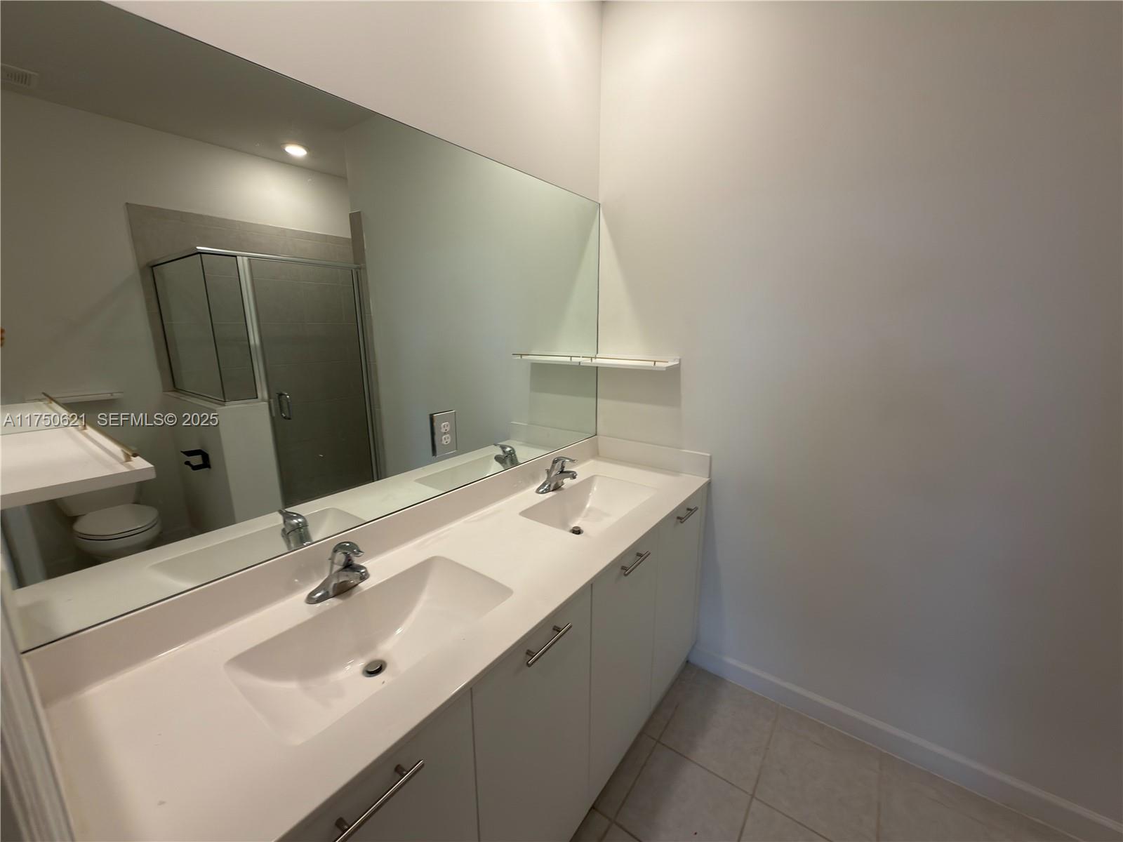 12909 Northwest 23rd Place, Unit 12909 Miami, FL 33167 - Photo 25 of 34 a bathroom with a sink and a mirror