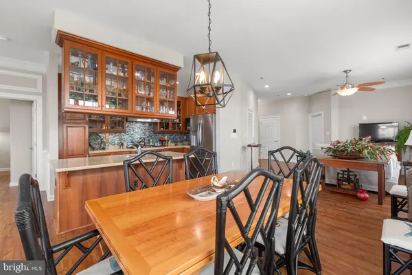 a kitchen with stainless steel appliances granite countertop a sink dishwasher and a refrigerator with wooden floor