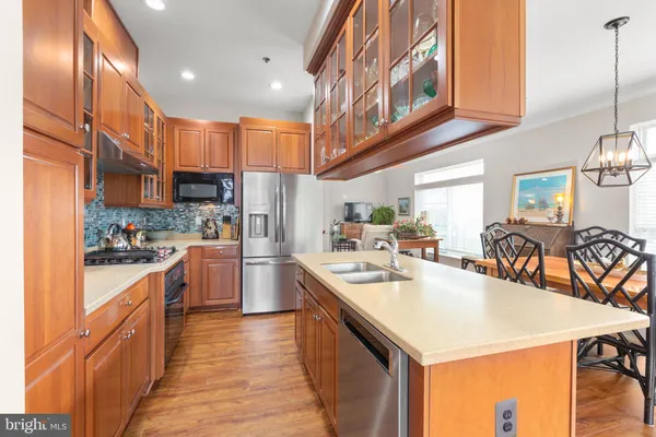 a kitchen with stainless steel appliances granite countertop a sink a stove and a wooden floors