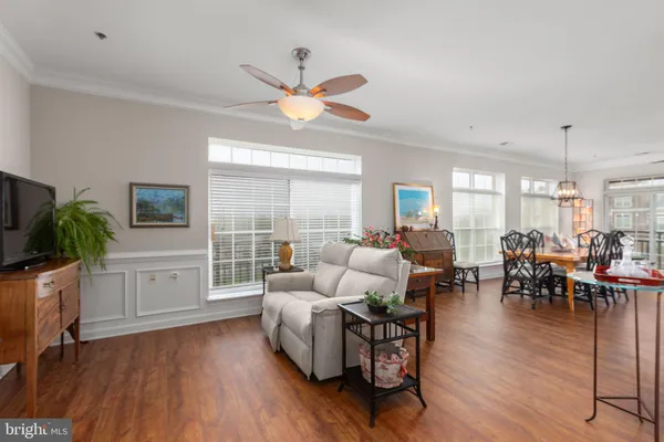 a living room with furniture a wooden floor and a chandelier