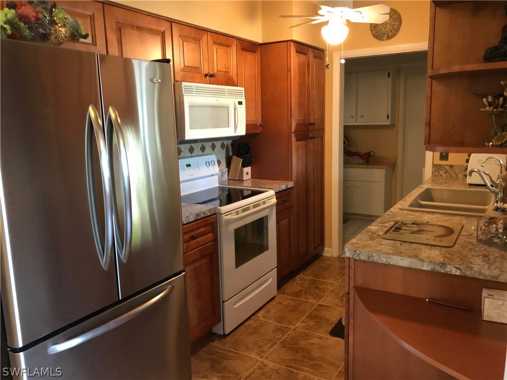 1439 Collins Road Fort Myers, FL 33919 - Photo 3 of 20 a kitchen with stainless steel appliances granite countertop a refrigerator stove and sink