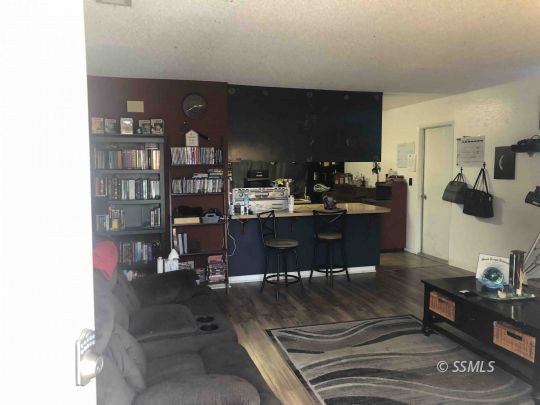 125 South Broadway Street Ridgecrest, CA 93555 - Photo 4 of 24 a living room with furniture and a book shelf