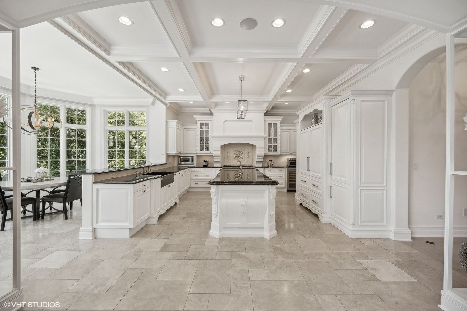67 Beach Road Glencoe, IL 60022 - Photo 13 of 43 a large white kitchen with kitchen island a stove a sink a dining table and chairs