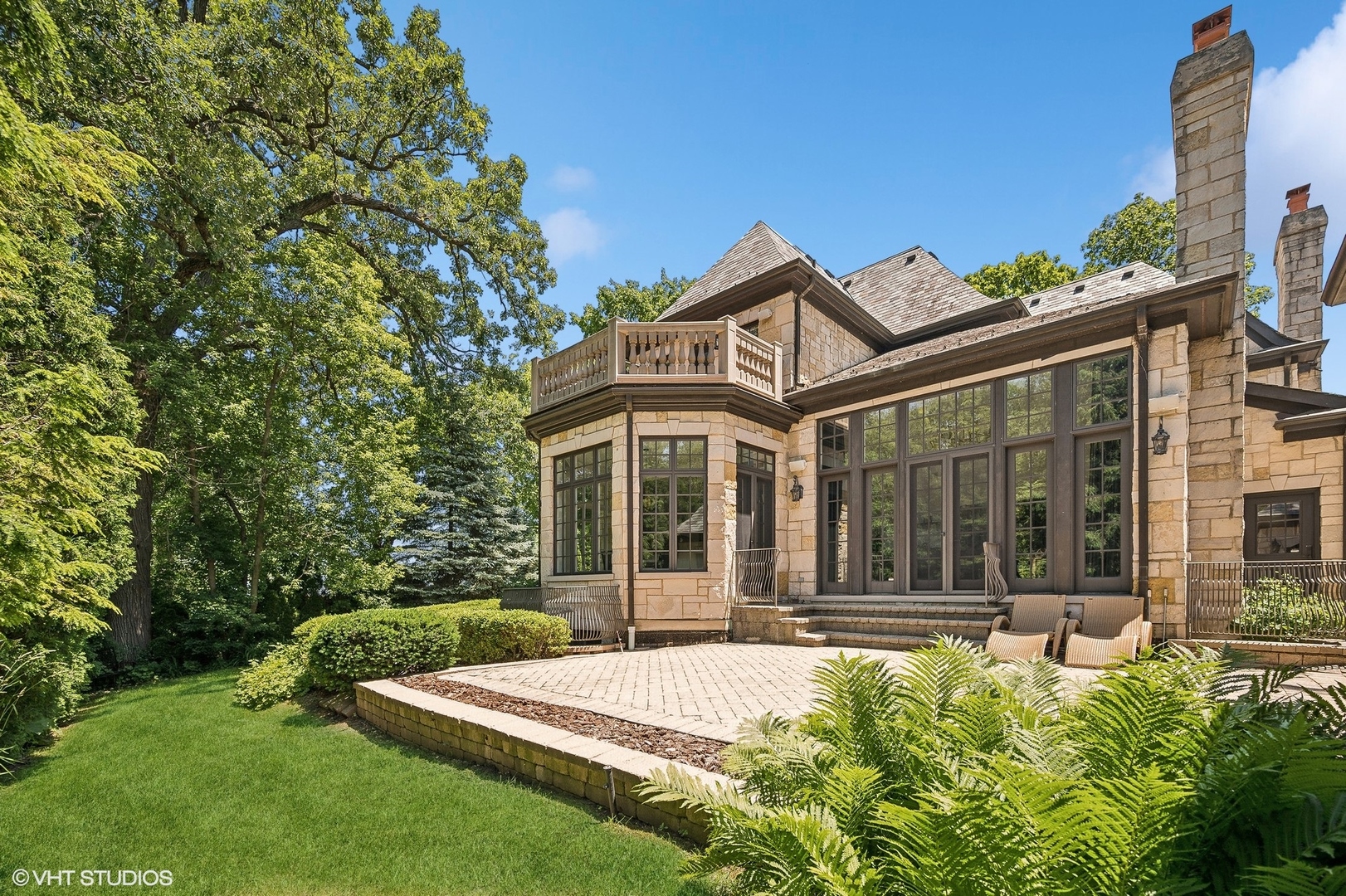 67 Beach Road Glencoe, IL 60022 - Photo 32 of 43 a view of a white house with a large windows and a yard with table and chairs
