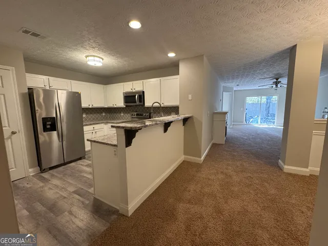 a kitchen with stainless steel appliances granite countertop a refrigerator a stove a sink and a refrigerator