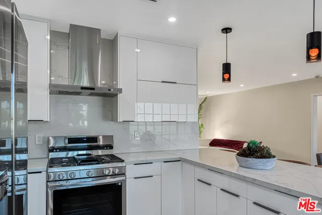 a kitchen with stainless steel appliances granite countertop a sink stove and cabinets