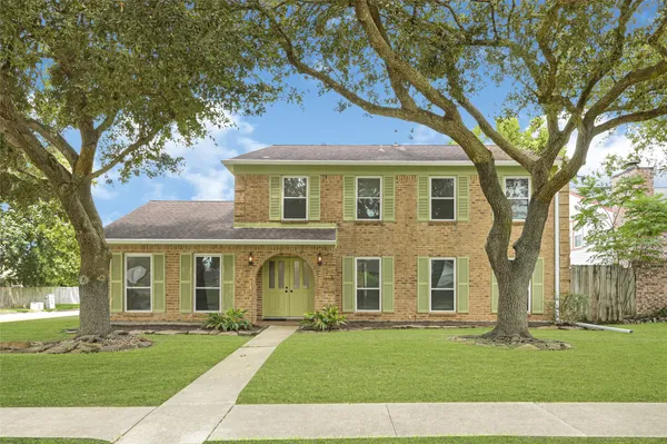 front view of a brick house with a yard