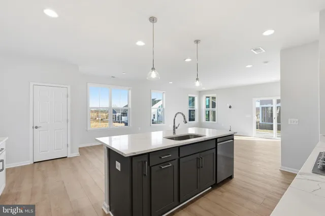 a kitchen with a sink cabinets and wooden floor