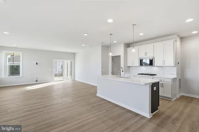a kitchen with kitchen island a sink stainless steel appliances and cabinets