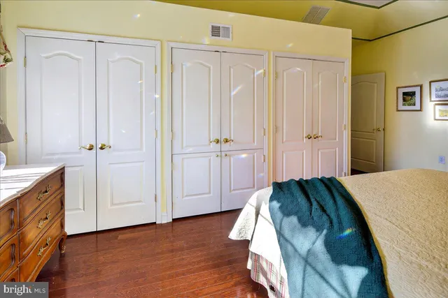 a view of bedroom with hardwood floor and cabinet
