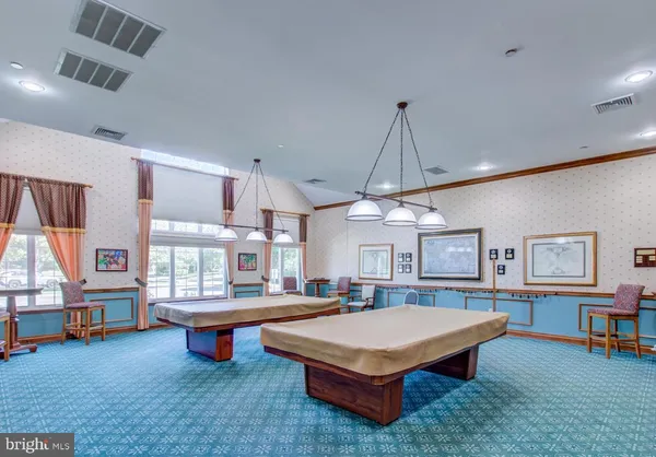 a living room with furniture a pool table and a large window