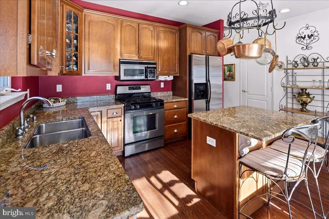 a kitchen with stainless steel appliances granite countertop a stove a sink and a refrigerator