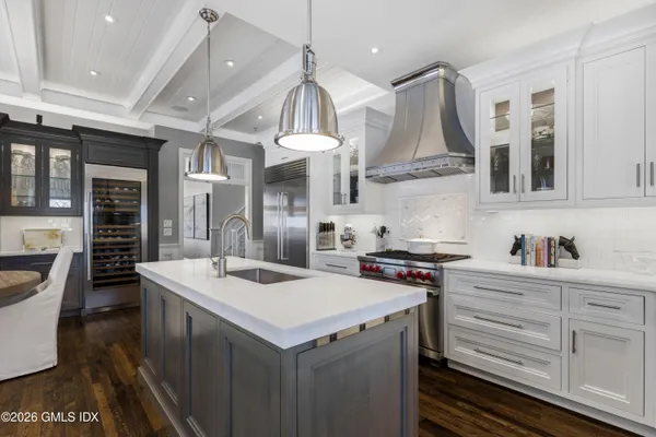 a kitchen with a sink stove and wooden floor