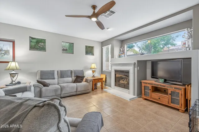 a living room with furniture a large window and a fireplace