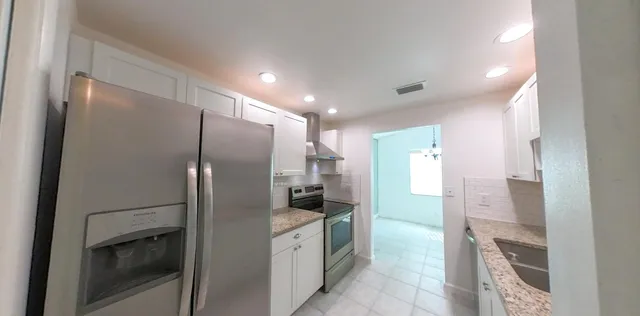 a large kitchen with a sink a refrigerator and a stove