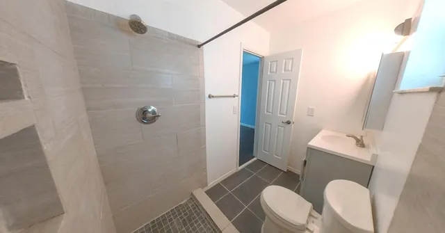a bathroom with a sink a toilet and shower