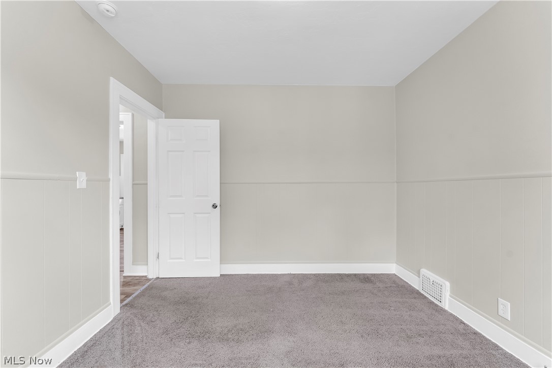 18123 McCracken Road Maple Heights, OH 44137 - Photo 15 of 27 Carpeted room featuring light gray walls, white trim, and wainscoting